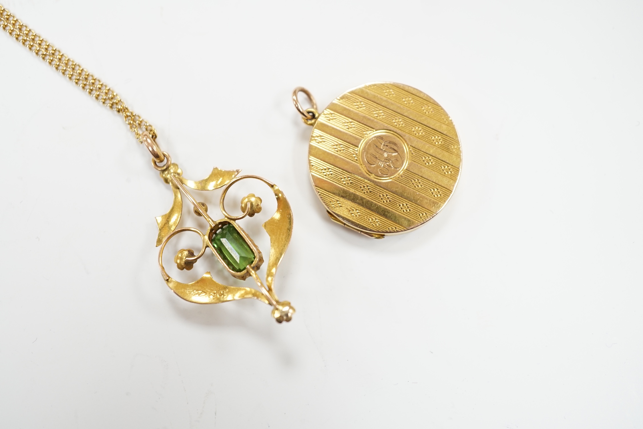 An Edwardian Art Nouveau 9ct, green tourmaline? and seed pearl set pendant, 37mm, on a gilt metal chain, together with a '9ct back and front' locket.